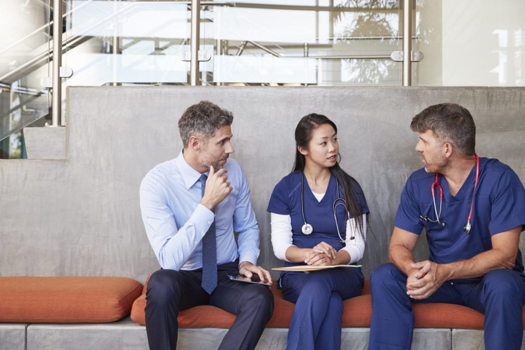 healthcare workers discussing paperwork with an insurance salesman
